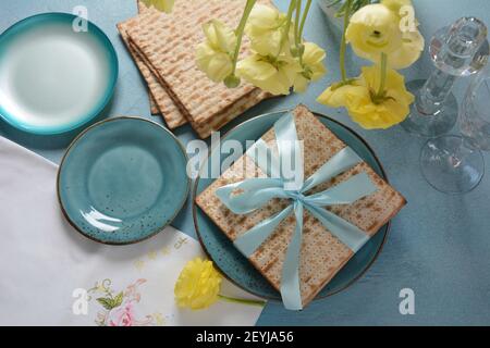 Tavolo servito per la Pasqua (Pesach) al chiuso, con pane matzah come simbolo Pesach (Passover Seder) articolo. Foto Stock