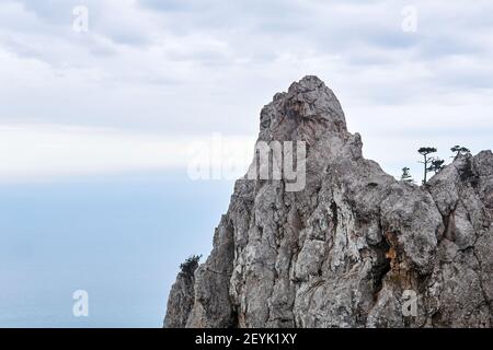 alte scogliere con alberi sparsi sul cielo nuvoloso d'inverno Foto Stock