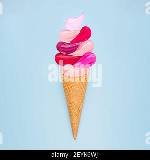 Concetto creativo di rossetto spalmato sotto forma di gelato alla papsicola su sfondo bianco. Piatto di orologi colorati trucco prodotto Foto Stock