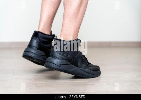 gambe di un uomo in sneakers primo piano sul pavimento laminato. sport e fitness Foto Stock