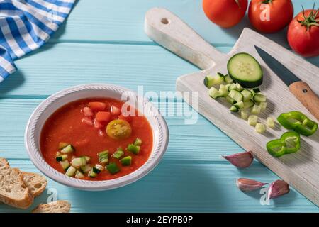 Gazpacho Andaluz è una zuppa fredda di pomodoro andalusa di Spagna con cetrioli, aglio, pepe su sfondo azzurro Foto Stock