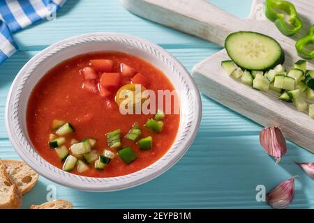 Gazpacho Andaluz è una zuppa fredda di pomodoro andalusa di Spagna con cetrioli, aglio, pepe su sfondo azzurro Foto Stock