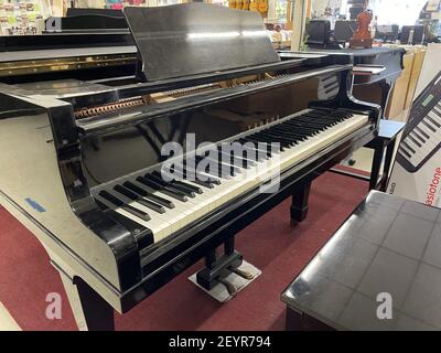 FRESNO, STATI UNITI - 15 gennaio 2021: Una foto di un piano Yamaha nero su un tappeto rosso con panca in Music Store Foto Stock