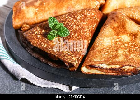 Frittelle dolci sottili di cucina russa. Blini russi, crepes su sfondo grigio. Vacanza Shrovetide. Foto Stock