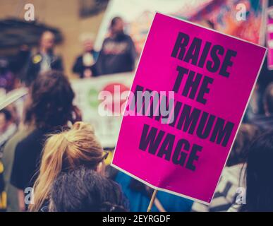 Un segno di aumento del salario minimo alla protesta dei diritti dei lavoratori O Rally Foto Stock