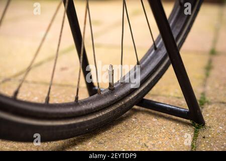 Una ruota nera parcheggiata da vicino con vista prospettica Foto Stock