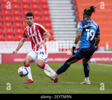 6 marzo 2021; Bet365 Stadium, Stoke, Staffordshire, Inghilterra; Campionato di calcio inglese, Stoke City contro Wycombe Wanderers; Goalkeeper Angus Gunn di Stoke City passa la palla oltre Hareth McCleary di Wycombe Wanderers Foto Stock