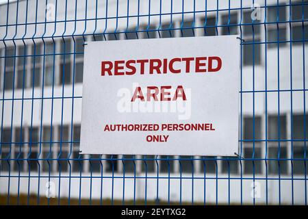 Area riservata, solo personale autorizzato: Avvertenza di sicurezza, nessun segnale di trasgressione. Lettere rosse, avviso di non chiusura sulla recinzione metallica, simbolo del bordo. Foto Stock