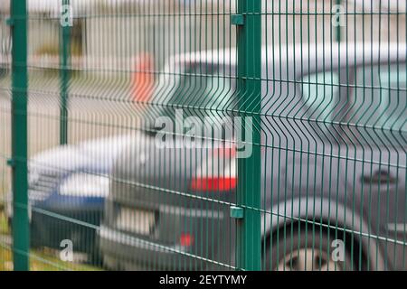 Parcheggio recintato con sicurezza. Territorio sorvegliato di parcheggio a pagamento orario. Sfondo delle auto sfocato Foto Stock