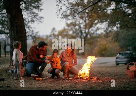 Famiglia con bambini in picnic in legno fuoco chiaro Foto Stock