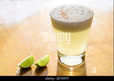 Un primo piano di un bicchiere di bevanda con i limoni su tavolo di legno Foto Stock