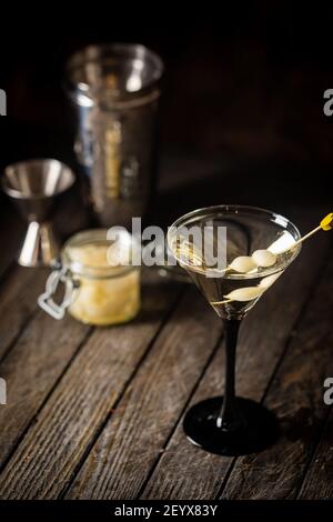 Cocktail Gibson con martini e cipolle in bicchiere martini. Cocktail decorato su sfondo scuro Foto Stock