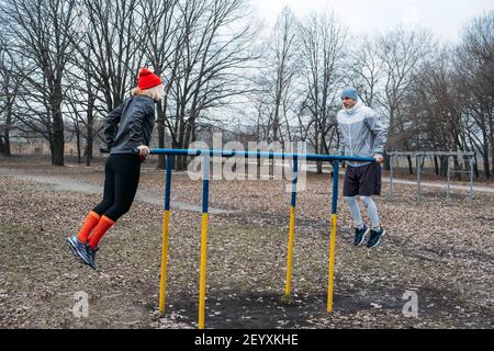 Corsi di fitness di gruppo all'aperto. Corsi di ginnastica organizzati nei parchi pubblici. Tre donne e tre uomini si allenano insieme nel parco pubblico. Salute Foto Stock