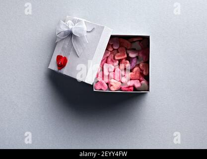Aprire la confezione regalo con un sacco di carino cuori piccoli Foto Stock