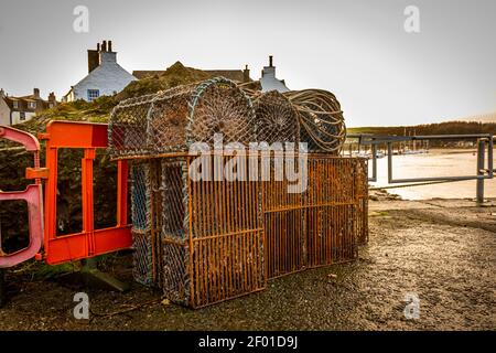 Pentole e canne per la pesca di aragoste e gamberi accatastati a Kirkcudbright Harbour, Dumfries e Galloway, Scozia Foto Stock