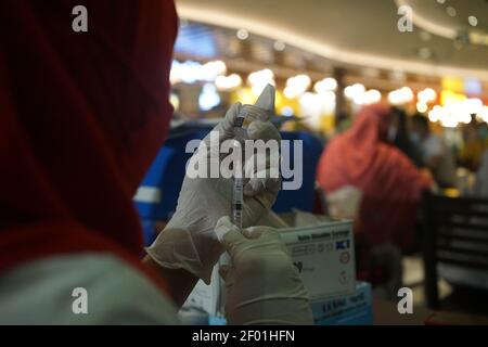 Makassar, Indonesia. 06 marzo 2021. Gli operatori sanitari hanno messo il liquido vaccino Covid-19 in una siringa durante le attività di vaccinazione di massa di centinaia di dipendenti del Trans Studio Mall Makassar. Le attività di vaccinazione sono destinate a prevenire e sopprimere la diffusione del virus corona ai lavoratori nei centri commerciali. (Foto di Herwin Bahar/Pacific Press) Credit: Pacific Press Media Production Corp./Alamy Live News Foto Stock