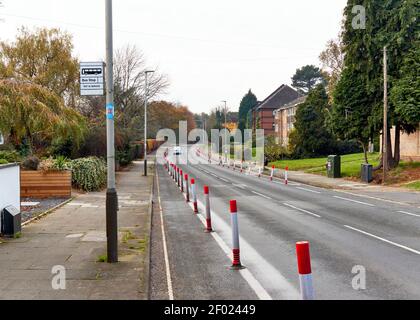 Mostra un'auto su una strada alberata con le nuove piste ciclabili pop-up intorno alla città di Leicester. Foto Stock