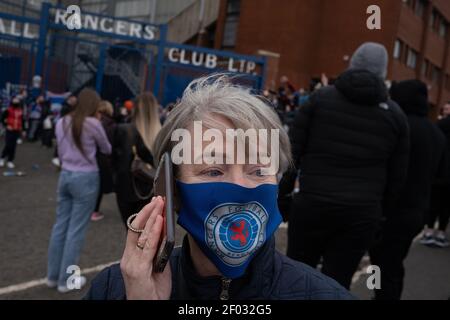 Glasgow, Scozia, il 6 marzo 2021. I fan del Rangers Football Club sfidano Covid-19 le regole di blocco pandemiche del coronavirus per riunirsi all'esterno dello Ibrox Stadium per celebrare l'imminente vittoria del titolo della squadra e sfidare in modo significativo i rivali dell'arco, il Celtic FC, la possibilità di vincere il titolo 10 volte di fila. Foto: Jeremy Sutton-Hibbert/Alamy Live News. Foto Stock