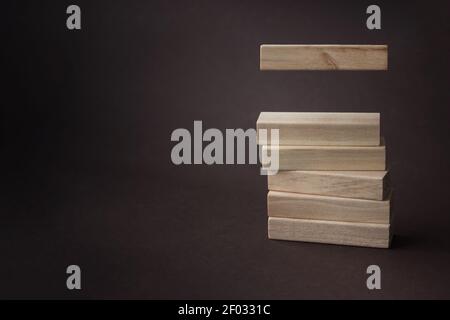 Torre cubetti di legno, su sfondo marrone. Strategia di business mock up, spazio di copia. Concetto di fasi di sviluppo aziendale Foto Stock