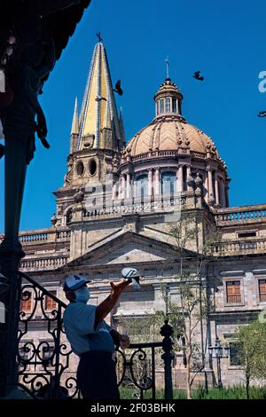 Nutrire gli uccelli alla Cattedrale di Guadalajara nel centro storico, Guadalajara, Jalisco, Messico Foto Stock