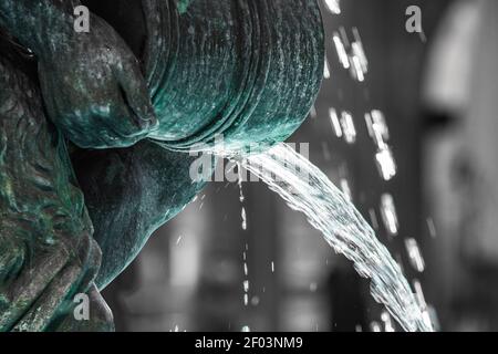 Primo piano di acqua che scorre in una fontana che produce piccolo perle e belle forme Foto Stock