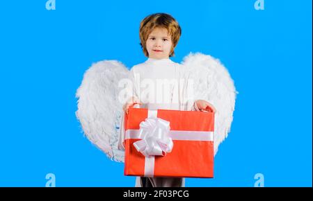 Piccolo angelo con ali bianche con presente. Bambino con confezione regalo. San Valentino, natale o anno nuovo. Foto Stock