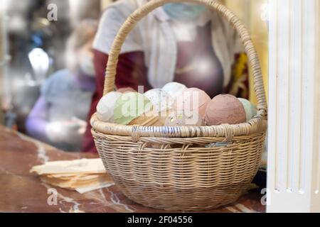 Porzioni di gelato di diversi colori in un cesto di vimini sul bancone del negozio. Foto Stock