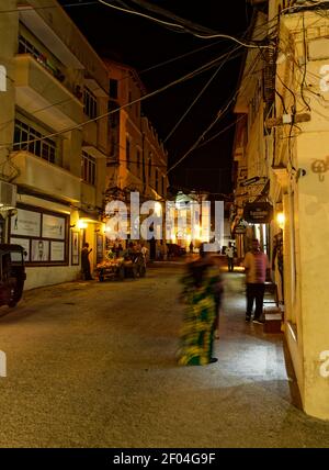 Stonetown (Tanzania, Arcipelago di Zanzibar) di sera e di notte. Strade e porto nella vecchia città di pietra di Zanzibar, storico edificio coloniale Foto Stock