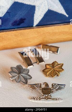 L'esercito AMERICANO Rank insignia accanto ad un caso piegato della bandiera, Stati Uniti Foto Stock