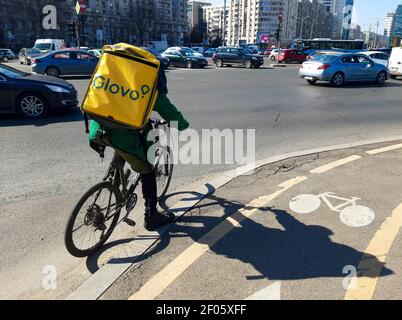 Bucarest, Romania - 03 marzo 2021: Un corriere di consegna del cibo di Glovo consegna il cibo a Bucarest, Romania. Foto Stock