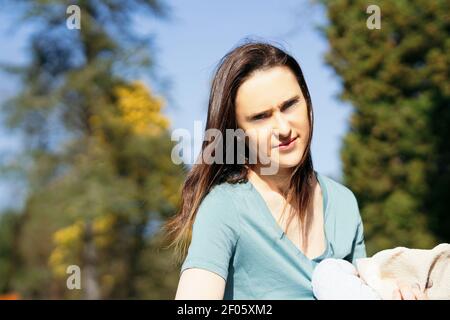 ritratto di donna che tiene il figlio in un parco in primavera o in estate. Foto Stock