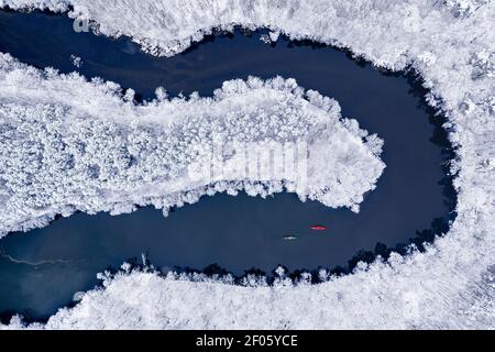 Kayak sul fiume invernale. Sport estremo in inverno. Kayak tra la foresta innevata. Vista aerea della natura in Polonia Foto Stock