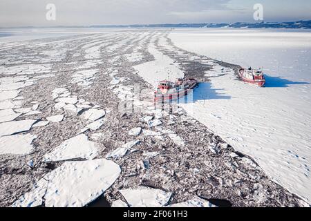 Due rompighiaccio che schiacciano ghiaccio sul fiume Vistola in inverno, Polonia, Plock, vista aerea della natura Foto Stock