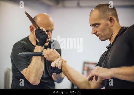 Istruttore e studente pratica spada lunga e coltello escima filipino tecnica di combattimento. Dimostrazione di arti marziali Foto Stock