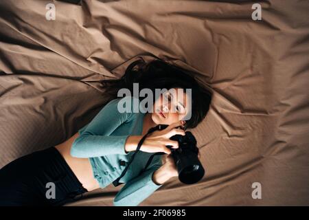 Concentrato tecnico etnico maschile in camicia scacchi cercando tablet mentre in piedi vicino al pannello fotovoltaico situato nella moderna centrale solare Foto Stock