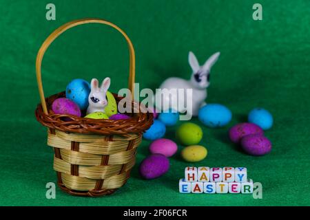 Buon coniglio di Pasqua in cestino con uova colorate Foto Stock