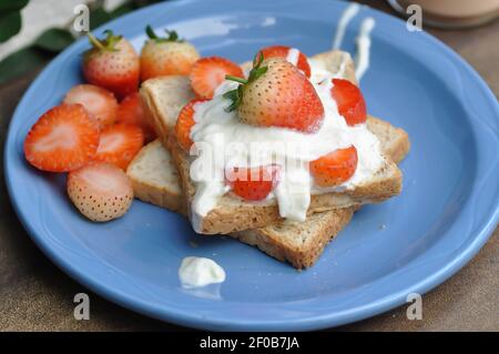 pane, pane tostato con panna montata e crema di fragole Foto Stock