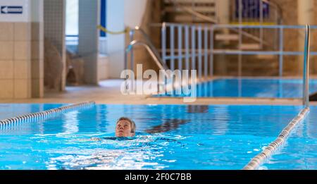 Schneverdingen, Germania. 06 marzo 2021. Rosie Warnke nuota nella piscina coperta Heidjers Wohl. Nella zona di chiusura di Corona, le piscine interne sono chiuse. Nella brughiera di Lüneburg, tuttavia, un operatore ha trovato una soluzione che permette agli ospiti di nuotare comunque. Credit: Philippe Schulze/dpa/Alamy Live News Foto Stock