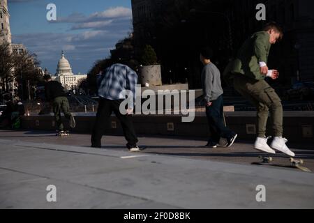 Washington, Stati Uniti. 06 marzo 2021. Gli skateboarders in Freedom Plaza con il Campidoglio degli Stati Uniti visto sullo sfondo, a Washington, DC, sabato 6 marzo, 2021, in mezzo alla pandemia del coronavirus. Il Senato ha approvato il progetto di legge del Presidente Biden, da 1.9 trilioni di dollari, sulla COVID con alcune modifiche alla precedente versione della Camera di oggi, dopo molteplici sessioni notturne e intensi negoziati di questa settimana. (Graeme Sloan/Sipa USA) Credit: Sipa USA/Alamy Live News Foto Stock