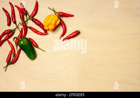 peperoni in diversi colori e forme su legno sfondo Foto Stock