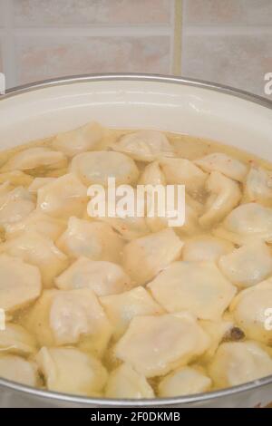 Gnocchi fatti in casa in brodo caldo con spezie. Primo piano della pentola, messa a fuoco selettiva. Foto Stock