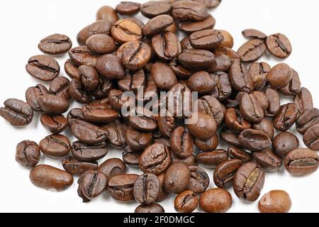 Cumulo di chicchi di caffè arrosto isolato su sfondo bianco, primo piano Foto Stock