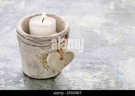 Portacandele in pietra con cuore. Metafora della perdita e della mormoratura. Foto Stock
