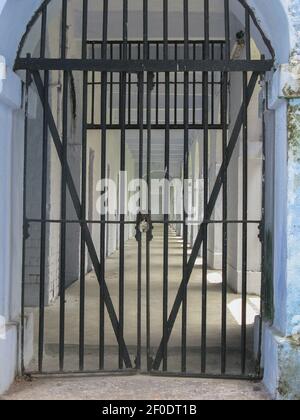 Iron Grill Gate fatto di barre di ferro con un blocco in un edificio carcerario Foto Stock