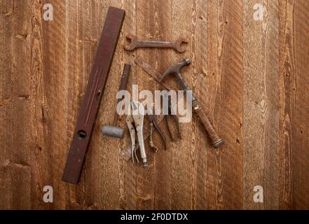 vecchi attrezzi di lavorazione del legno arrugginiti su tavole di legno di bardatura in difficoltà Foto Stock