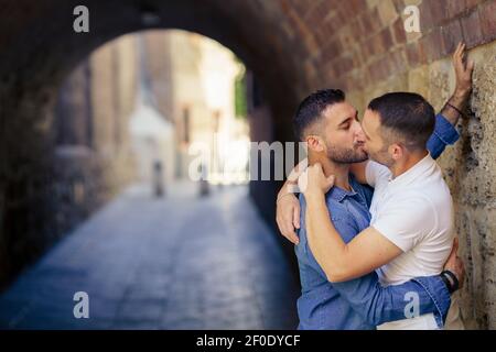 Coppia gay baciando in un momento romantico all'aperto Foto Stock