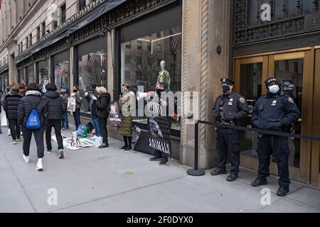 NEW YORK, NY - 6 MARZO: Gli ufficiali di polizia di NYPD assicurano gli ingressi del negozio durante una protesta dell'oca del Canada davanti al negozio principale di Saks Fifth Avenue il 6 marzo 2021 a New York City. Attivisti per i diritti degli animali protestano pacificamente di fronte a Saks Fifth Avenue. Protestando specificamente il marchio Canad Goose, che questo rivenditore vende. I manifestanti hanno invitato Saks Fifth Avenue a smettere di vendere 'prodotti' fatti con pelliccia da chinchilla, volpi, agnelli, mink, cani da raccoon e conigli. Credit: Ron Adar/Alamy Live News Foto Stock