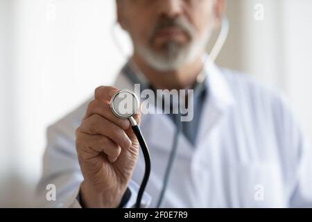 Primo piano dello stetoscopio di uso medico maschile maturo Foto Stock