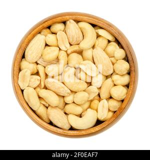 Noci miste tostate e salate in un recipiente di legno. Snack alimentari, costituiti da un miscuglio di arachidi, anacardi, nocciole e mandorle sgranate. Primo piano. Foto Stock