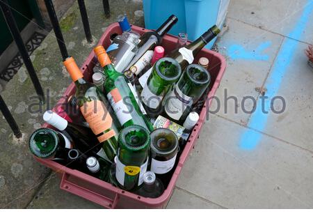 Bottiglie di vetro vuote in gabbia sul marciapiede in attesa del ritiro del consiglio per il riciclaggio Foto Stock